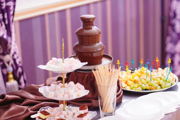 chocolate fountain with marshmallows and fruits 