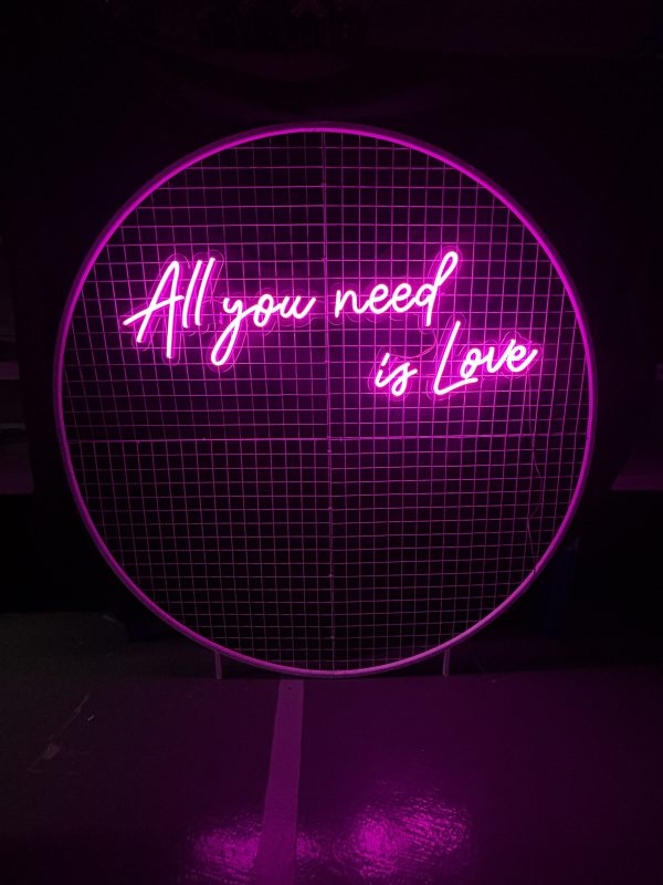 all you need is love sign on white round mesh backdrop