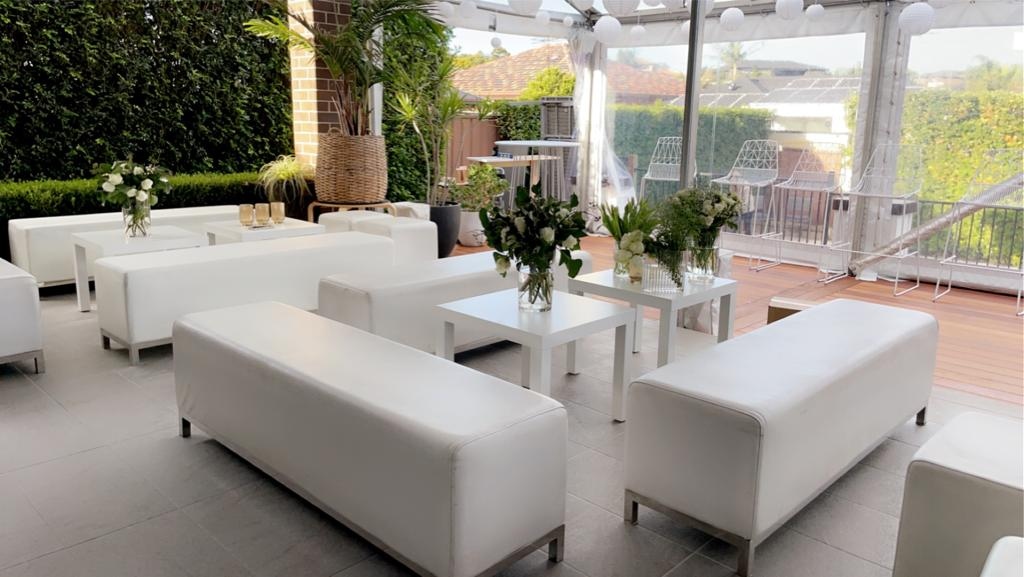 backyard event with white ottoman benches and cubes
